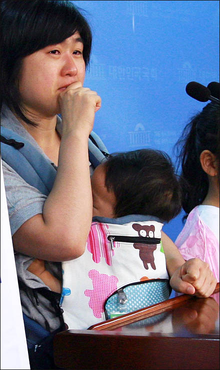 한진중공업 해고자 가족인 도경정씨가 생후 11개월 된 아들(김성민)을 안고 나와 22일 국회 정론관에서 "우리 애기아빠를 돌려달라" 눈물로 호소하고 있다.