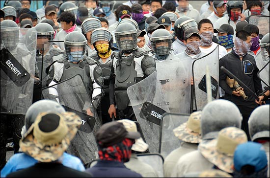 2011년 6월 22일 오전 충남 아산시 유성기업에서 헬멧과 마스크로 얼굴을 가리고 방패를 든 회사측 용역업체 직원들이 출근을 시도하는 노조원들 2백여명에게 쇠파이프, 죽창을 휘두르고 소화기를 던지는 등 폭력을 행사하는 모습.
