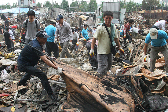 포이동 판자촌 주민들이 화재현장을 수습하고 있다.