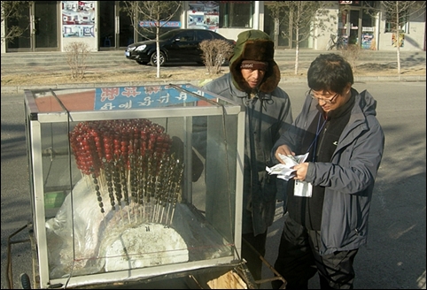 빙당고를 값을 계산하는 인솔자 김두현씨(오른쪽). 만주에는 거리 곳곳에 ‘빙당고’ 손수레가 있었습니다. 
