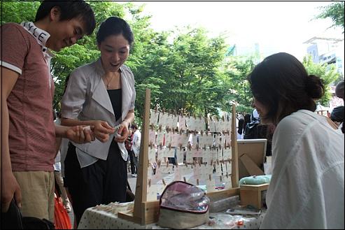  도자기 공예 악세서리 예술품을 가지고 나온 신수희 작가, 관람객과 즐거운 대화를 나누고 있다