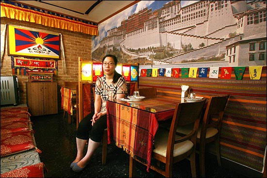 티베트 국기와 포탈라궁 사진이 붙어 있는 '포탈라' 식당 테이블에 앉아 있는 이근혜씨.