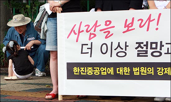 30일 오전 서울 서대문 경찰청 앞에서 열린 '한진중공업에 대한 법원의 강제집행 규탄과 공권력 투입 중단 촉구 기자회견'에서 기자회견에 참석하기 위해 상경한 전기원 한진중공업 조합원이 여섯 살 딸과 함께 이야기를 나누며 놀아주고 있다. 