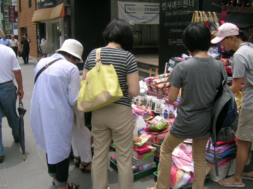 일본인 관광객이 거리에 널려진 상품을 구경하고 있다. 
비 온 뒤여서 인사동거리는 모처럼 한산하다. 