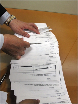 김명수 민주당 서울시의회 원내대표가 동일인의 필체로 대리서명된 무상급식반대 주민투표 청구인 서명부를 보여주고 있다. 