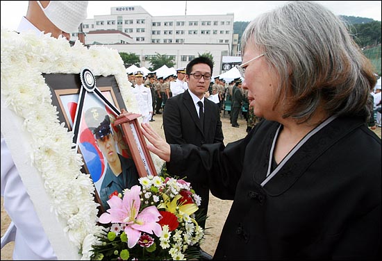  강화도 해병대 해안소초에서 발생한 총기사고로 희생된 고 이승훈 중사, 고 이승렬 병장, 고 박치현 병장, 고 권승혁 상병의 합동영결식이 6일 오전 경기도 분당 국군수도병원 연병장에서 해병대사령부 주관으로 열렸다. 관이 모두 운구차량에 실린 가운데 고 이승렬 병장의 어머니가 아들의 영정사진을 어루만지며 눈물을 흘리고 있다.