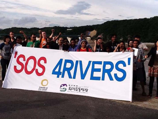 지구의 벗 소속 아시아태평양지역 단체 임원들이 지난 30일 4대강 사업이 벌어지고 있는 남한강 강천댐 현장을 방문해 한국 정부가 강행하는 4대강 사업의 즉각적인 중단을 촉구하며 'SOS 4RIVERS'라 써있는 현수막을 펼치고 있다.