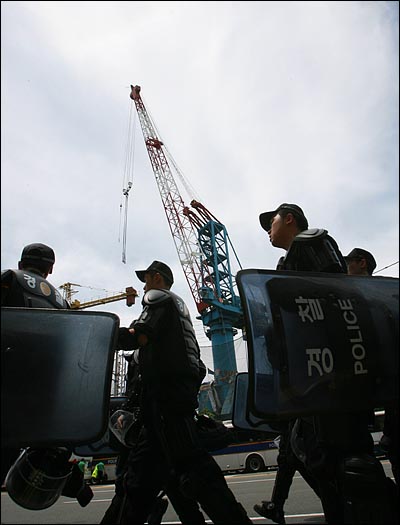  김진숙 민주노총 부산본부 지도위원이 부산 영도구 한진중공업 '85호 크레인'에서 정리해고 철회를 요구하며 186일째 고공농성을 벌이고 있는 가운데, 지난 10일 오후 경찰 병력들이 공장 주위를 지나고 있다. 경찰은 '정리해고·비정규직 없는 세상을 위한 2차 희망버스' 참가자들의 접근을 막기 위해 7천여명의 경찰을 한진중공업 주위에 배치했다.