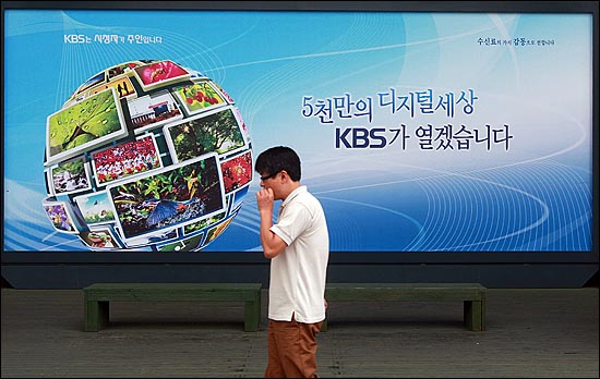 최근 'KBS 수신료 인상안' 추진과 관련해 민주당 대표실 도청 의혹 사건이 불거지고 있는 가운데, 11일 오후 서울 여의도 KBS 본관 앞에서 한 시민이 KBS 수신료와 관련된 광고판 앞을 지나가고 있다.