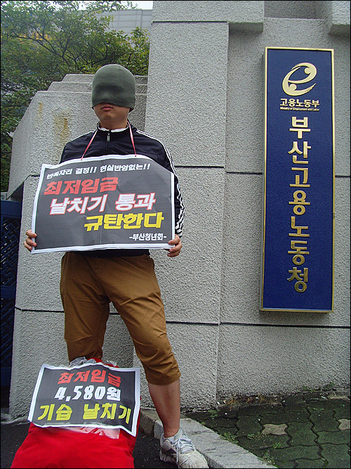 부산청년회는 13일 부산고용노동청 앞에서 “최저임금 날치기 처리 규탄 1인 시위, 퍼포먼스”를 벌이고 있다.