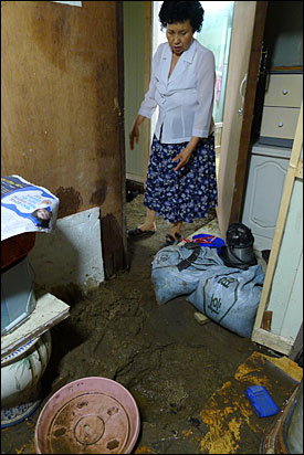 과천 비닐하우스 쪽방촌에 사는 이명심 할머니에게 빗물을 집밖으로 퍼내는 일은 너무 고된 일이다.
