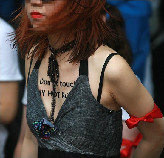 '슬럿워크(Slutwalk) 잡년행진 - 벗어라 던져라 잡년이 걷는다'에 참석한 한 여성의 가슴에 'Don't touch!(손대지마!)"가 적혀 있다.