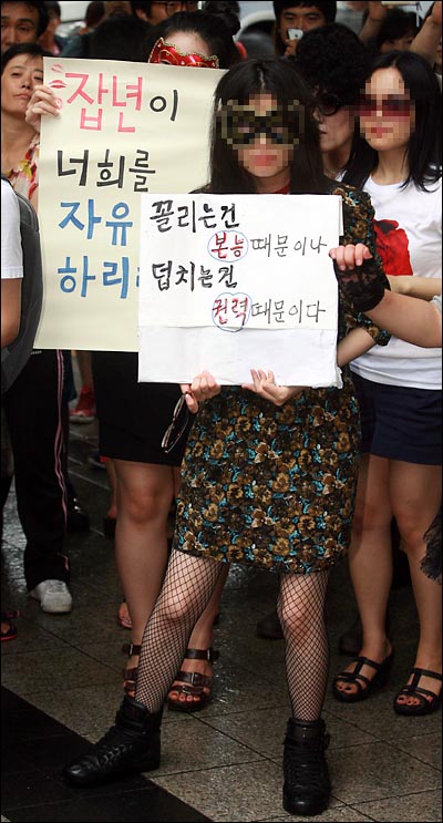  '슬럿워크(Slutwalk) 잡년행진 - 벗어라 던져라 잡년이 걷는다' 참석자들이 "잡년이 너희를 자유롭게 하리라" "꼴리는 건 본능 때문이나, 덮치는 건 권력때문이다"가 적힌 피켓을 들고 있다.