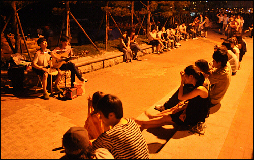 길거리 공연을 즐기는 피서객들. 기타와 젬베 만으로도 훌륭한 선율이 완성되었다.