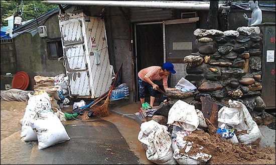산사태가 일어난 서울 방배동 남태령 전원마을. 주민이 삽으로 토사를 제거하고 있다. (엄지뉴스 전송: 6572님)
