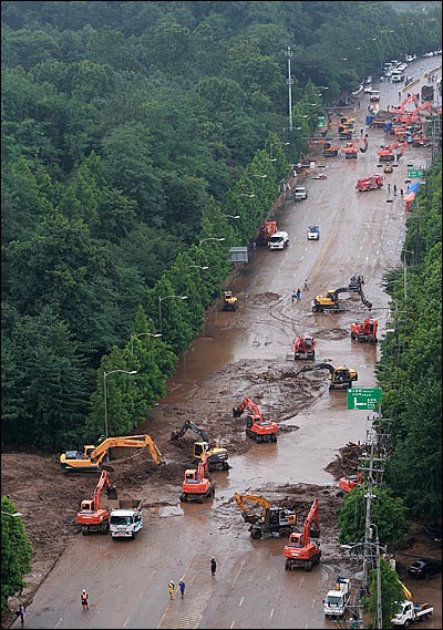 지난 2011년 7월 집중 폭우로 우면산 산사태가 발생한 가운데, 서울 서초구 방배동 일대 남부순환도로에서 현장 복구에 동원된 중장비들이 토사 제거 작업을 벌이고 있다. <자료사진>