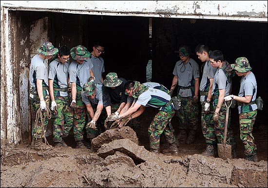 군인 장병들이 2011년 7월 서초 방배동 우면산 산사태 피해지역에서 복구 작업을 벌이고 있다. 