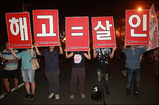  '3차 희망버스' 참가자들이 지난 2011년 7월 30일 저녁 부산 영도구 봉래삼거리에서 한진중공업 '85호 크레인'에서 206일째 정리해고에 반대하며 고공 농성중인 김진숙 민주노총 부산본부 지도위원을 만나기 위해 행진을 벌이며 '해고=살인'라는 피켓을 들어보이고 있다.