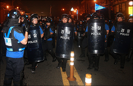  전,의경들이 7월 30일 저녁 부산 영도구 봉래삼거리에서 '3차 희망버스' 참가자들이 한진중공업 정리해고 철회를 요구하며 고공 농성중인 김진숙 민주노총 부산본부 지도위원을 만나기 위해 행진을 벌이자, 경찰병력이 이를 막고 있다.