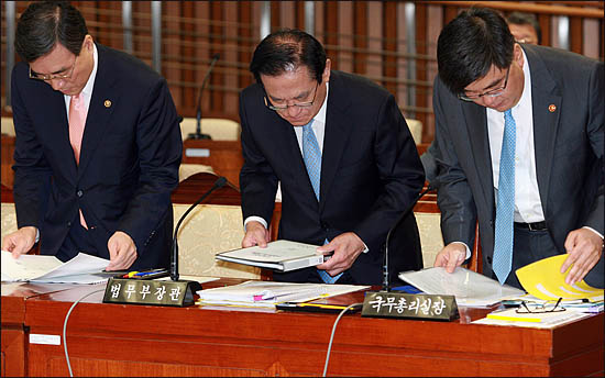  2일 국회에서 열린 저축은행 국조특위 기관보고에 출석한 임채민 국무총리실장, 이귀남 법무부 장관, 홍정기 감사원 사무총장이 나란히 자료를 보고 있다.