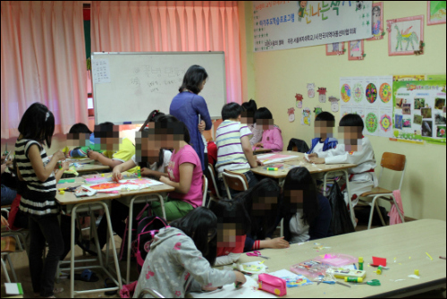 ‘사랑의 교실’ 아이들이 그림심리치료 프로그램 시간에 조별로 모자이크 꽃병을 만들고 있다.