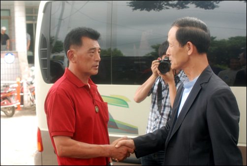 참여정부 시절 국방장관을 지낸 김장수 의원(한나라당, 국방위)이 강정마을을 방문해 강동균 마을회장과 악수를 하고 있다.  
