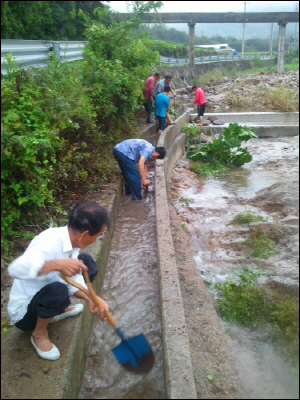 마을 자체 울력으로 수해를 복구해 나가는 수평리 마을. 마을 사람들이 비가 갠틈을 타서 막힌 수로를 뚫고 있다(8월 11) 