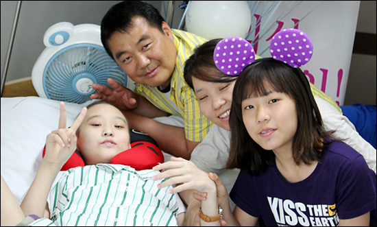 아빠 장영선씨와 엄마 이춘호씨 그리고 동생 수빈양과 포즈를 취한 예은양(왼쪽)이 수술하기 전, 손가락으로 브이 자를 그리고 있다.
