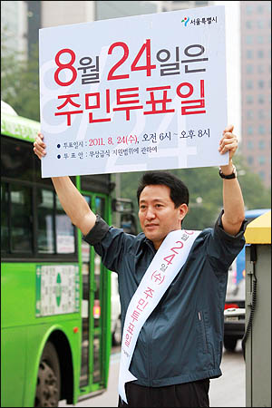 오세훈 서울시장이 지난 17일 오전 서울 을지로 입구에서 주민투표일을 알리는 피켓을 들고 출근하는 시민들에게 무상급식 주민투표 참여를 호소하고 있다.