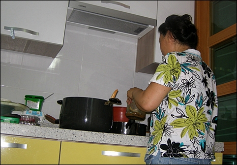 주방에서 손님에게 접대할 음식을 만들고 있는 조카며느리. 
