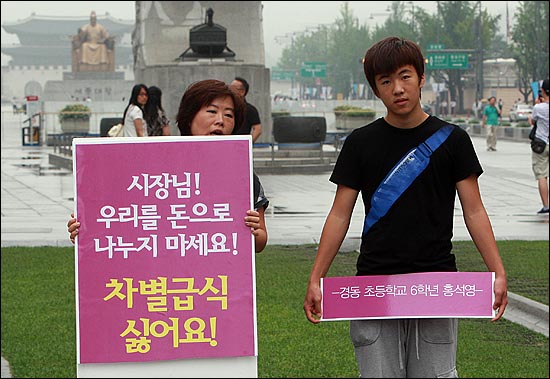 무상급식 주민투표를 일주일 앞둔 17일 오후 서울 광화문 광장 이순신 동상 앞에서 경동초등학교 6학년에 재학 중인 홍석영(12)군과 어머니 김희경(39)씨가 무상급식 주민투표에 반대하는 1인 시위를 벌이고 있다.