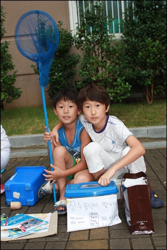  장수풍뎅이를 팔고 있는 소은빈(11살)과 후배 정우영(10살)어린이가 장터에서 포즈를 취하고 있다.