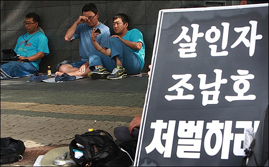 조남호 한진중공업 회장의 청문회가 열린 18일 오후 서울 여의도 국회 앞에서 한진중공업 정리해고 노동자들이 휴대폰을 통해 청문회 생중계를 지켜보고 있다.