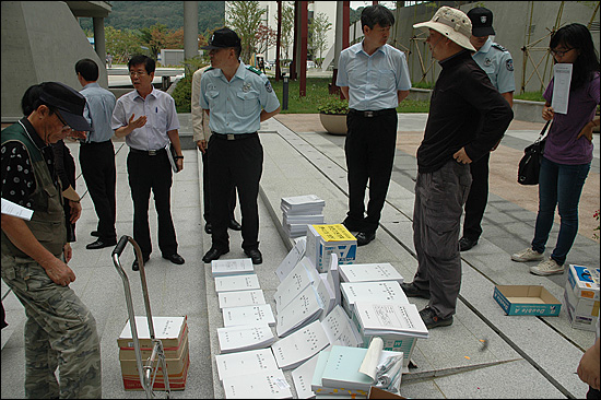  마산창원진해환경연합은 22일 오전 경남도청(별관) 현관 앞에서 기자회견을 열고 “경상남도는 하천관리 기본계획 용역의 구조적인 문제점을 개선하라”고 촉구했다. 사진은 관련 자료를 진열하자 경남도청 관리 담당자들이 나와 실랑이를 벌이는 모습.
