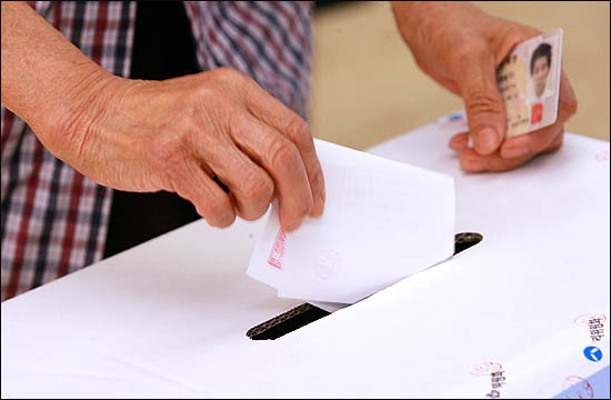 서울시 무상급식 주민투표일인 24일 오전 서울 종로구에 위치한 한 초등학교 교실에 마련된 투표소에서 주민들이 투표에 참여하고 있다.