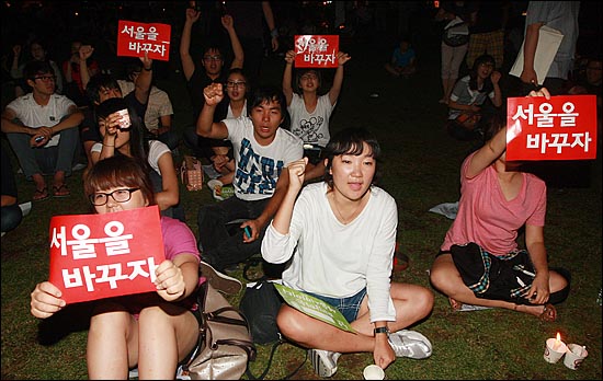 24일 밤 서울광장에 모인 대학생들이 '서울을 바꾸자'는 피켓을 들어보이며 오세훈 시장의 사퇴를 촉구하고 있다.