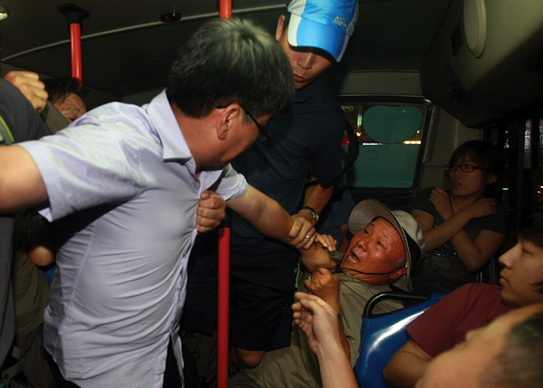 버스에 난입한 추선희 어버이연합 사무총장에게 멱살을 잡힌 채 끌려나오는 박석운 한국진보연대 공동대표