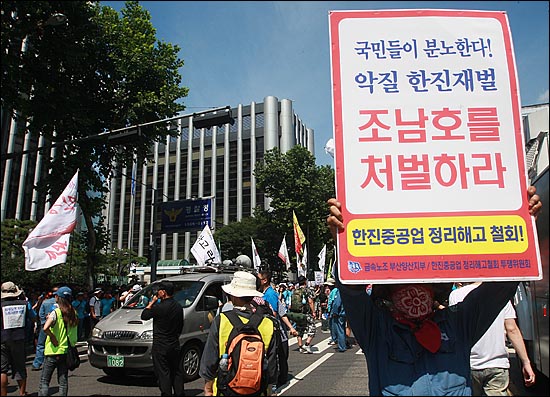 28일 오전 서울 서대문구 경찰청 앞에서 한진중공업 조합원이 거리행진을 벌이며 '국민들이 분노한다. 조남호를 처벌하라'라고 적힌 손피켓을 들어보이고 있다.
