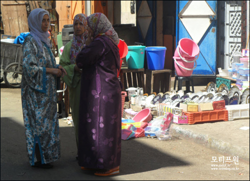 모로코 거리에서 일상적으로 볼 수 있는 모로코 여성들의 의상. 온몸을 다 가리면서 마법사를 연상시키는 모자가 달려있는 질레바에 히잡을 두른 모습.
