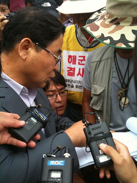 법원 집행관이 강정마을 대표자에게 고시내용을 전달하고있다.