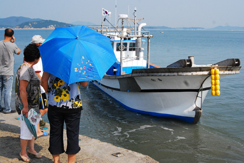지난 1일 김양자(48)씨가 화재로 불탄 선박을 대신해 새로 구입한 새 어선이 만대항으로 입항하는 모습을 바라보고 있다.
