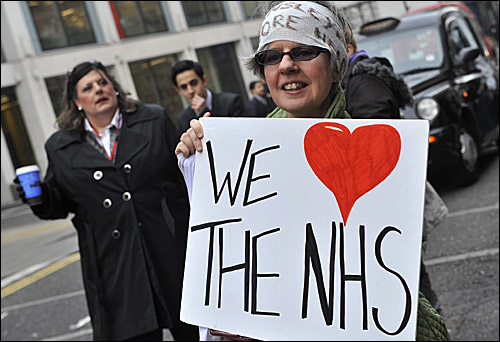 NHS를 사랑한다는 피켓을 들고 있는 한 영국 여성. 대부분 외국인들이 NHS에 비판적인 것과는 대조적으로 영국인들은 NHS를 자신들의 소중한 자산으로 받아들이고 있다.
