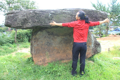 고인돌의 덮개석은 한 쪽 길이가 3.5m 정도에 이르는 큰 돌이다. 180cm의 장정이 팔을 벌리면 잘반을 조금 넘는다
