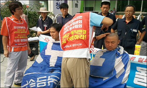  지난 8월 16일 대구지방고용노동청 앞에서 10억 손해배상청구소송을 낸 회사에 대해 항의하고 해고자 복직을 요구하며 조정훈씨와 김대용씨가 삭발을 하고 있다.