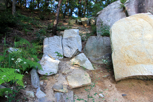 여기저기 흩어져 있는 조각난 돌. 그 돌에는 마애불의 흔적이 있다