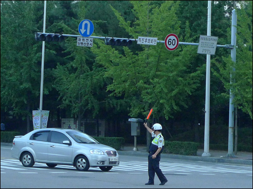 정전사태로 교통 신호등이 꺼지자 교통경찰이 수신호를 하고 있다. 