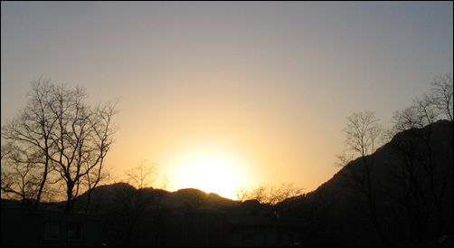 인왕산 너머로 사라지는 태양. 왼쪽 높은 봉우리가 인왕산 정상이다.

