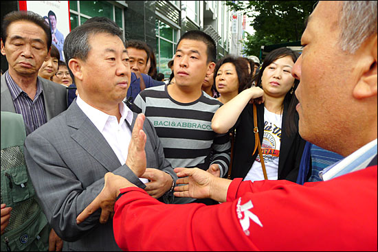 19일 오전 경기 성남시 수정구 신흥동 토마토저축은행 앞에서 신학규 회장이 예금자들을 뿌리치며 자리를 피하고 있다.