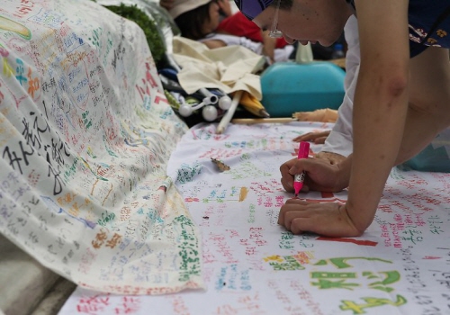 단식시위 중인 청년들을 응원 방문한 시민들이 펼침막에 평화의 메시지를 적어 넣고 있다.