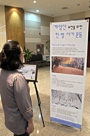  문화나눔 콘서트가 있었던 현장 로비에서 계양산한평사기 안내문을 보고 있는 관람객의 모습